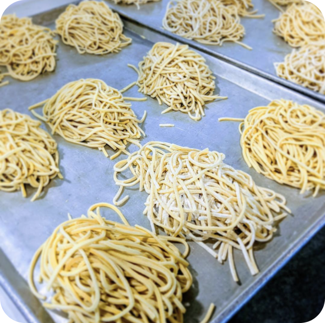 Fresh spaghetti noodles dusted and on a tray